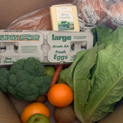 A food box including Cal Poly cheese, eggs and produce