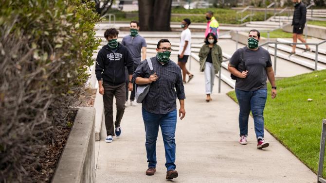 students walk around the campus with masks