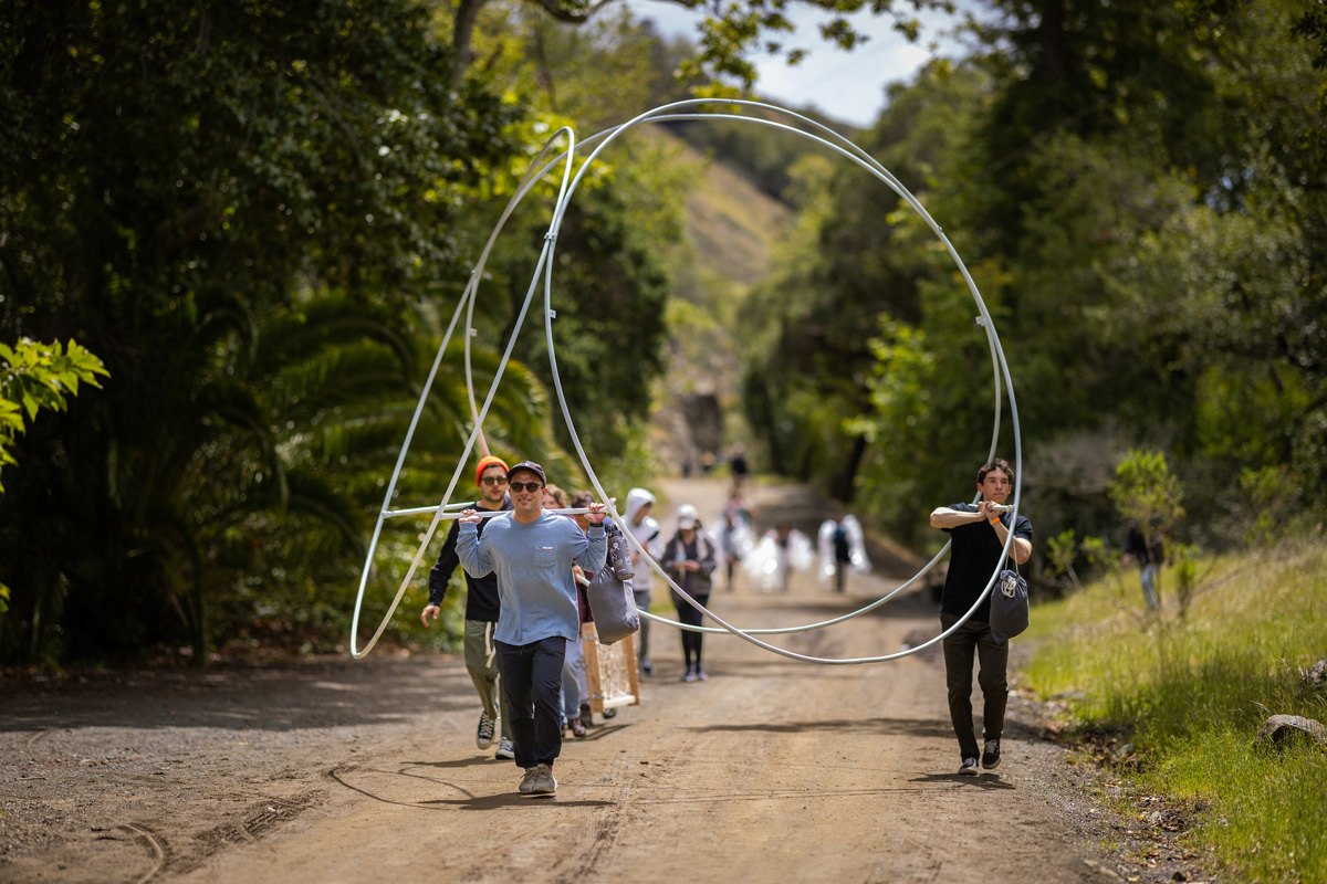 Students hike the mile-long trail with their materials before reaching Poly Canyon