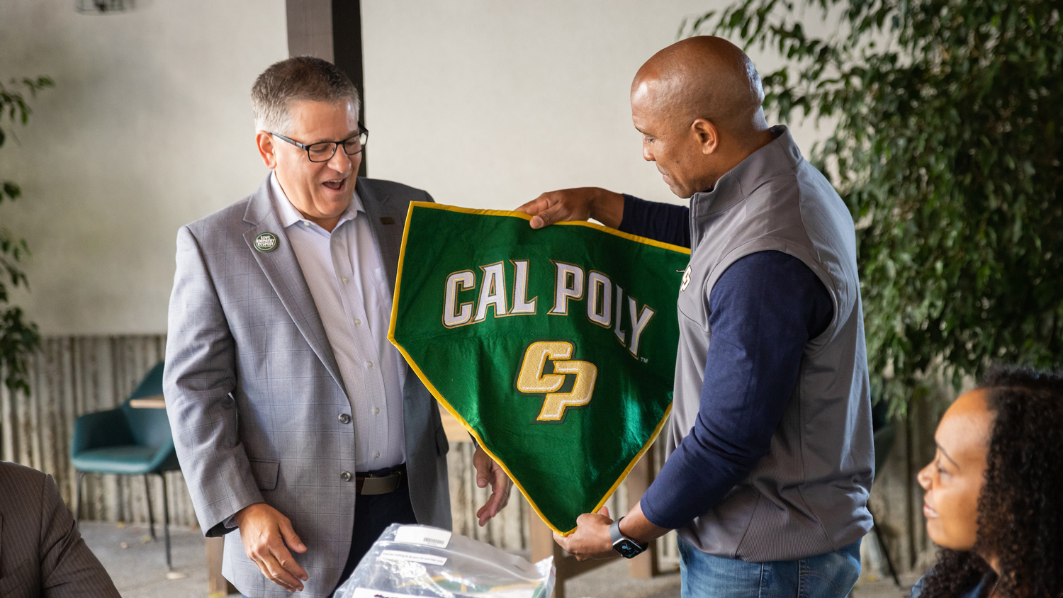 President Jeffrey D. Armstrong receives one of two Cal Poly banners that flew with Captain Victor Glover on the International Space Station