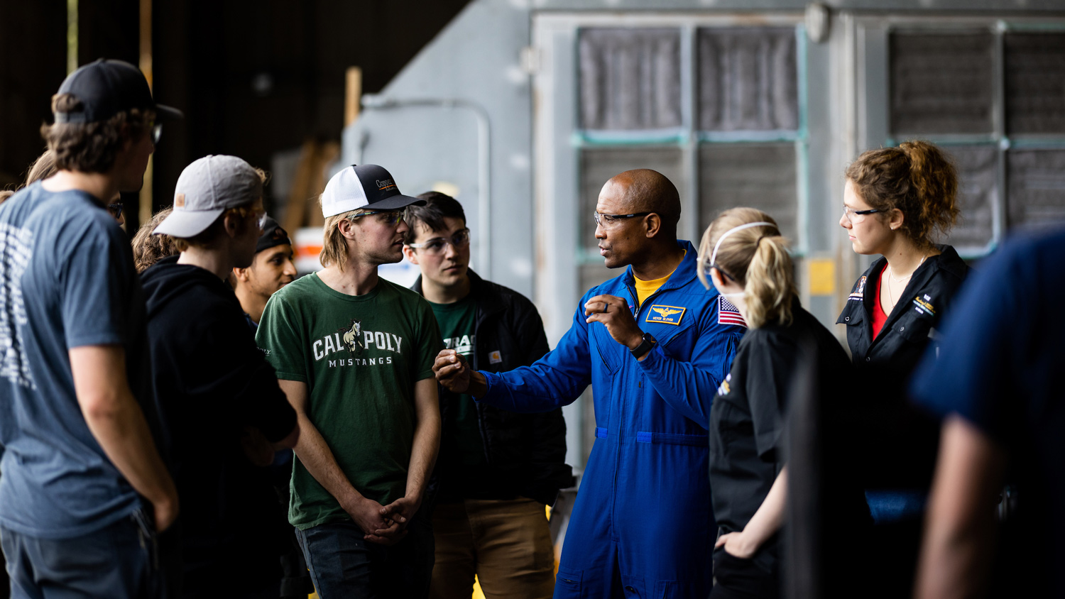 Victor Glover (center) talks to Mustangs at the on-campus Aerospace Engineering Hangar.