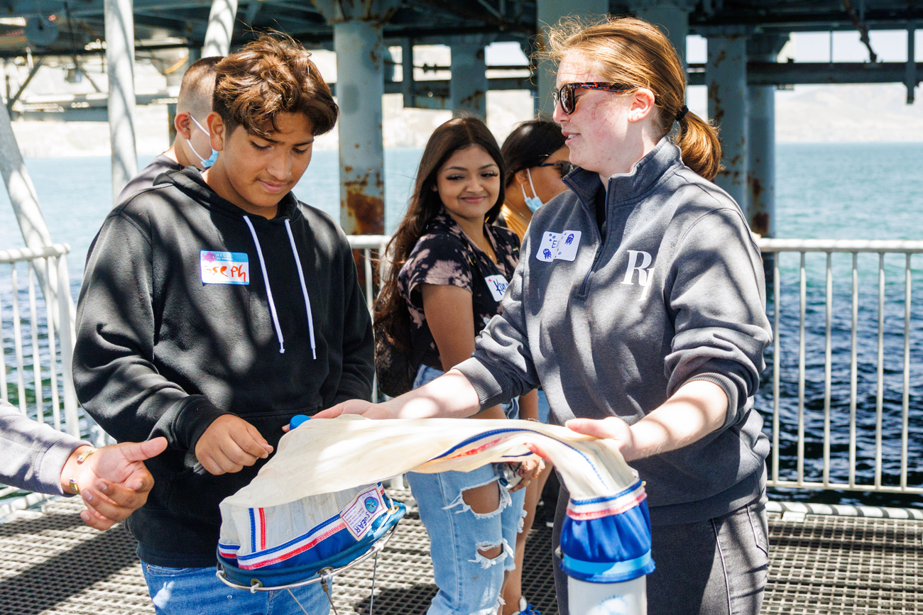 During a tour of the pier, students practiced capturing sea water to observe plankton.