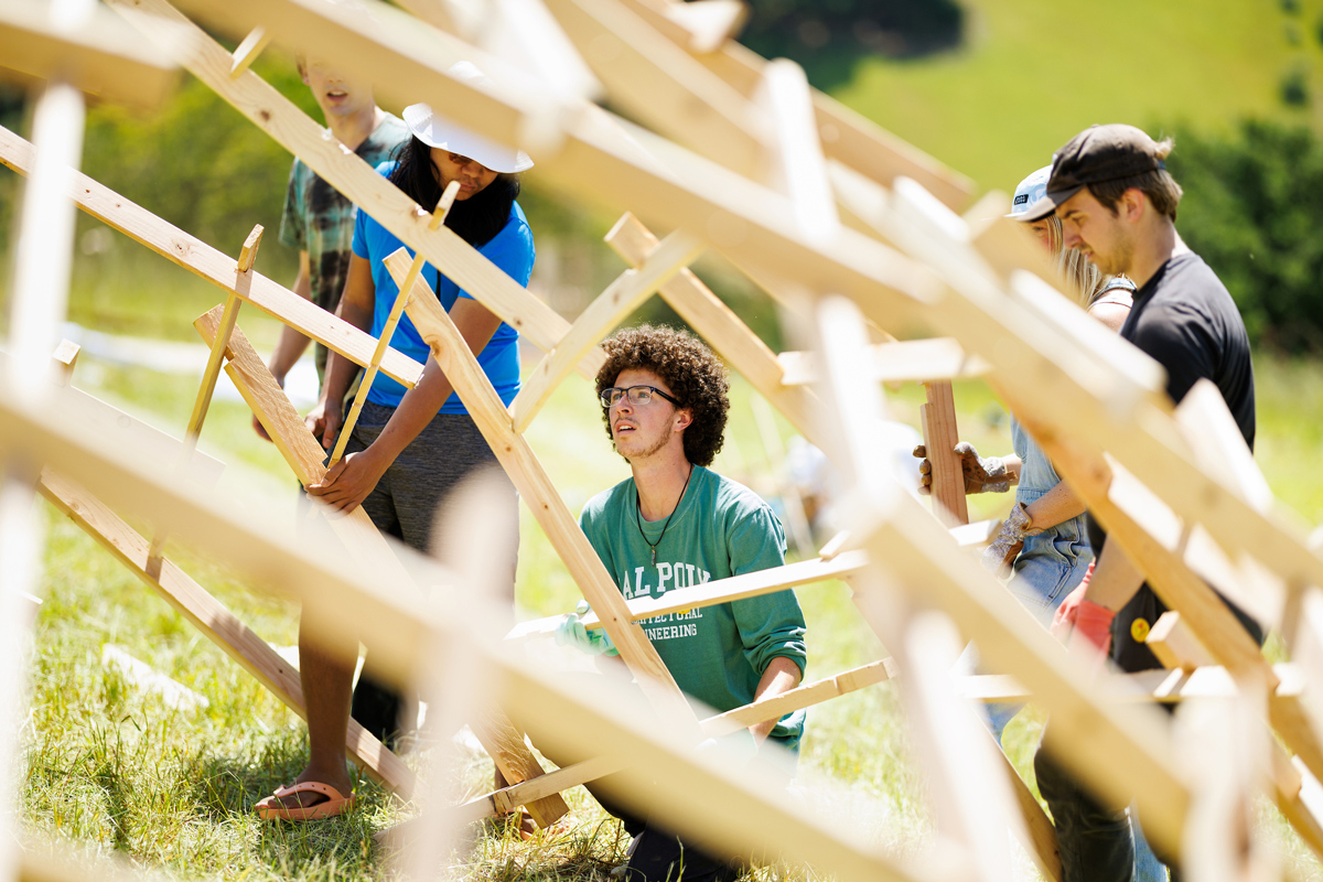 Students work on a wooden structure at Design Village. 