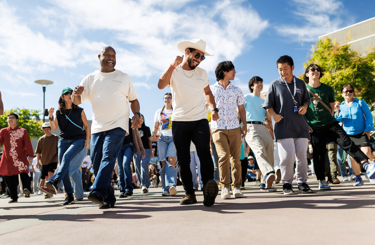 Campus community members smile and dance during CultureFest, an annual celebration of diversity through culture, food, and community that happens in October. 