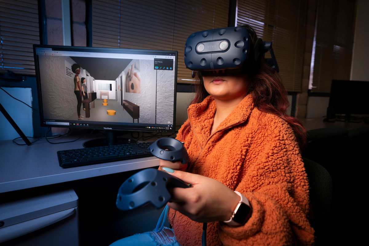 Cal Poly computer science major Zahnae Aquino uses an HTC VIVE headset and controllers to navigate a virtual reality environment that she created with fellow student Josie Grundler