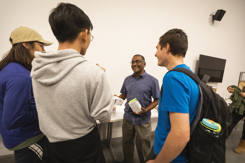 Nishi Rajakaruna, a professor who lives on campus, laughs with students during a recent tea night he hosted.