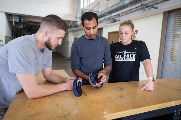 Biomedical engineering students Sahil Sharma, Ally Sigdestad and Cale Foreman analyze their prototype of a prosthetic thumb they designed for a Cal Poly Pomona student who lost his thumb in an industrial accident. Andrew Emmert, a Cal Poly Pomona student, is also working on the prototype.