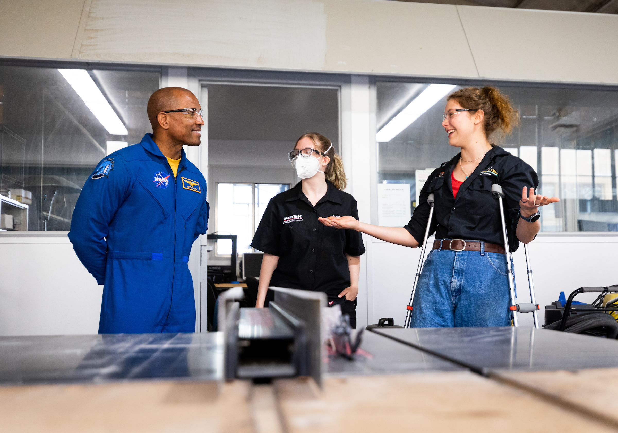 Alumnus Victor Glover visits with two female students at the Cal Poly Aero Hanger Machine Shop during his visit to campus in April.