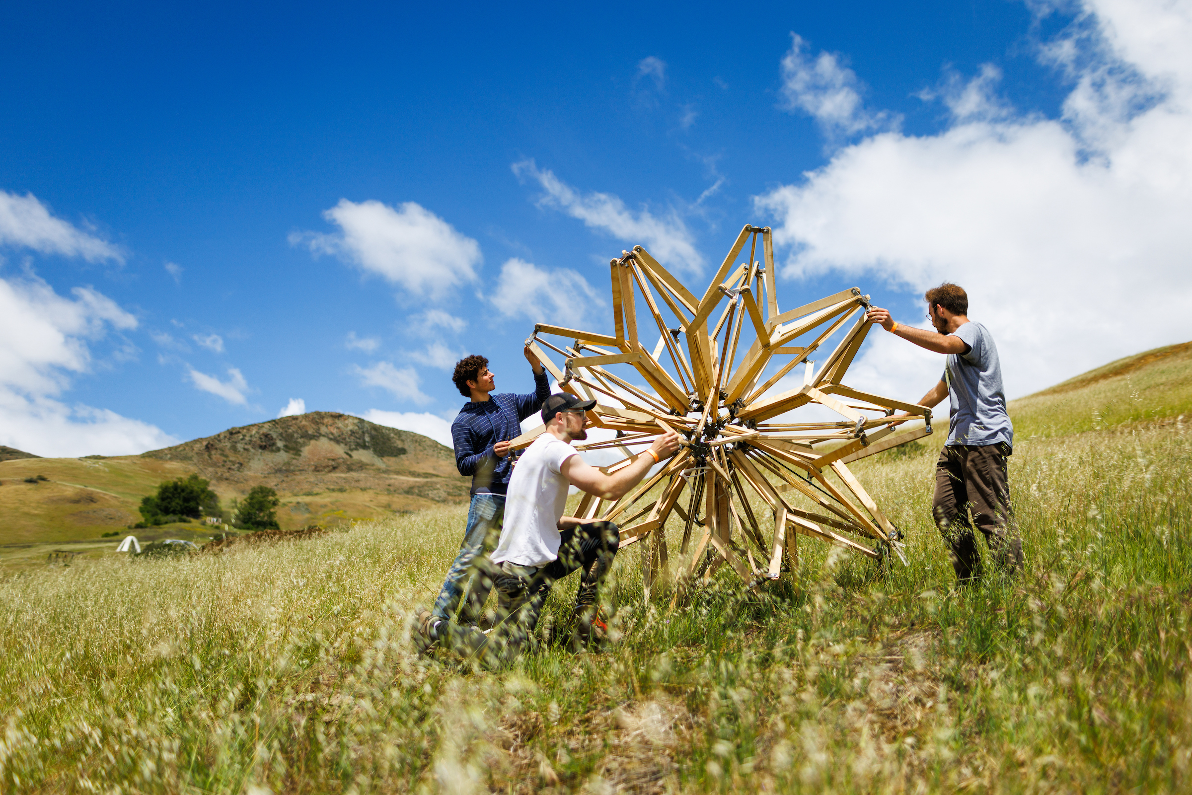 Architecture students set up a wooden spherical structure in Poly Canyon during design village.