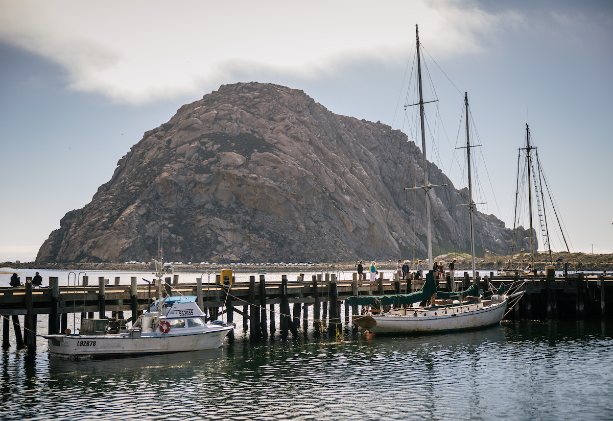A view of Morro Rock with the Coast Guard pier in the foreground, with Talke and his students on the pier.