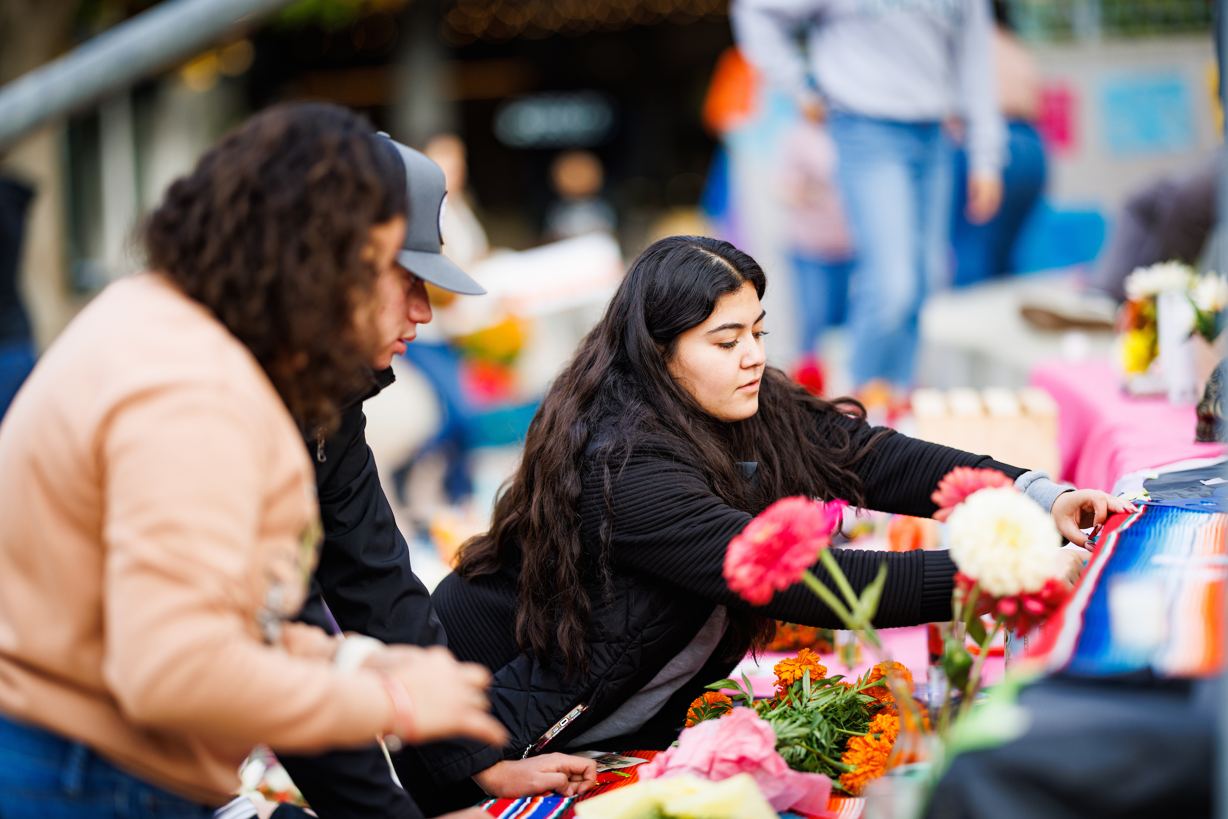 Students congregate at an ofrenda, or altar, for dia de los muertos in the university union plaza.