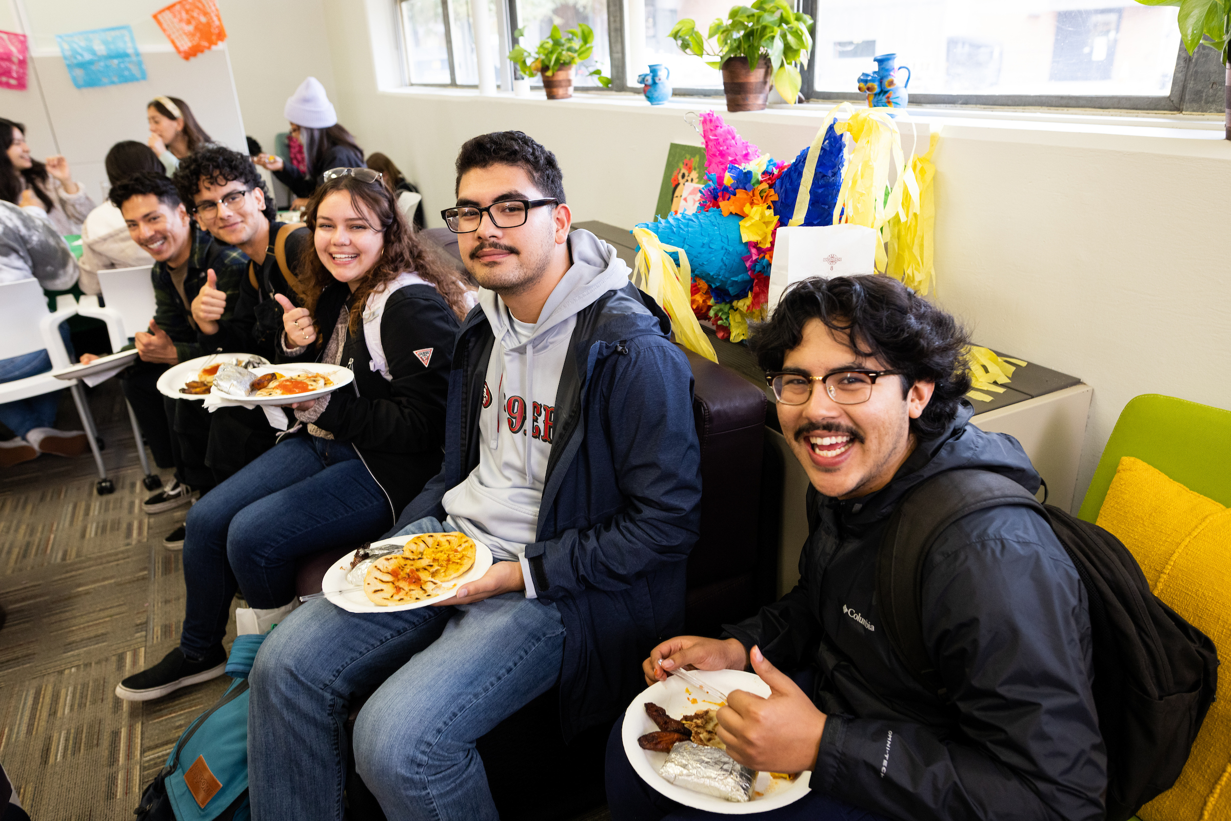 Students eating food and enjoying each other's company at the newly-opened latinx center.