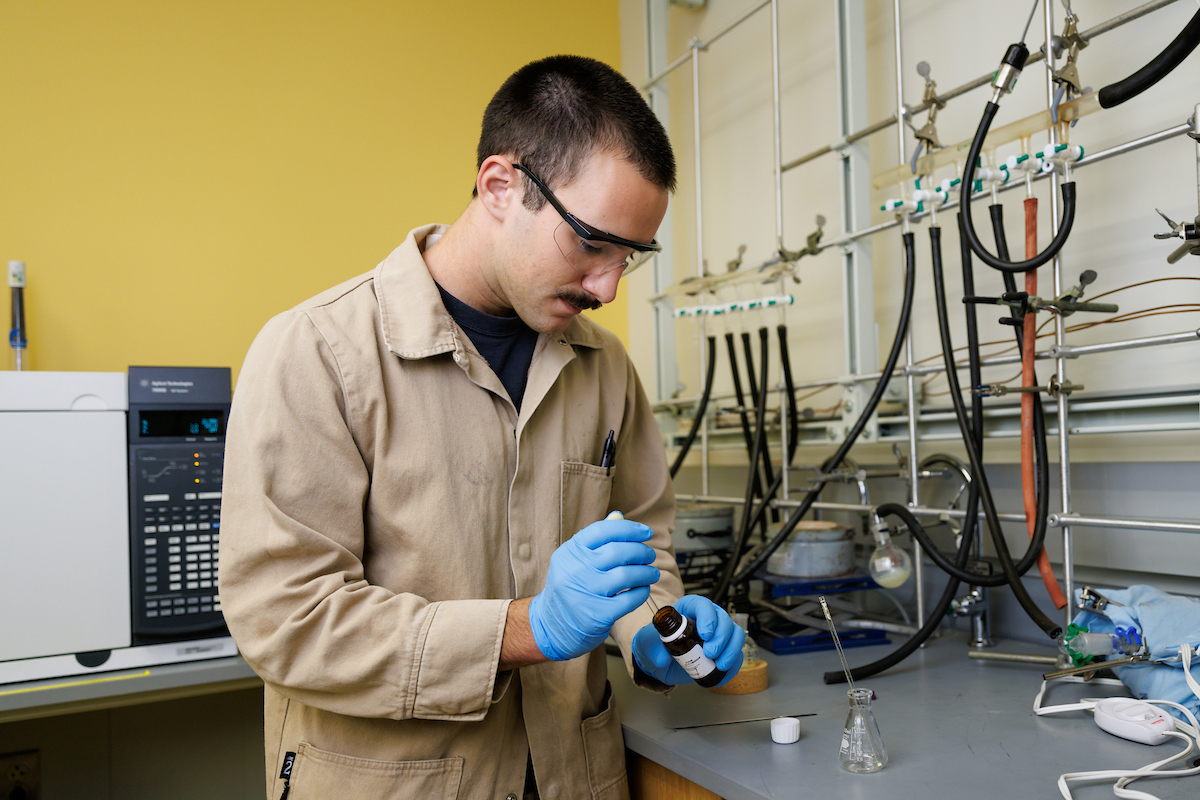 Chemistry student Sal Deguara works on derivative compounds in the lab wearing protective gear.