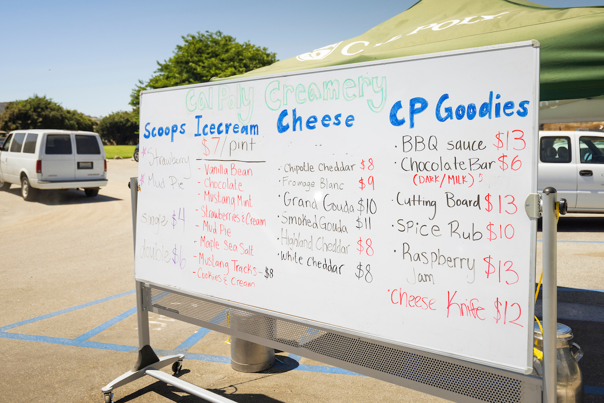 A dry erase board with ice cream, cheese and other Cal Poly-made items for sale.