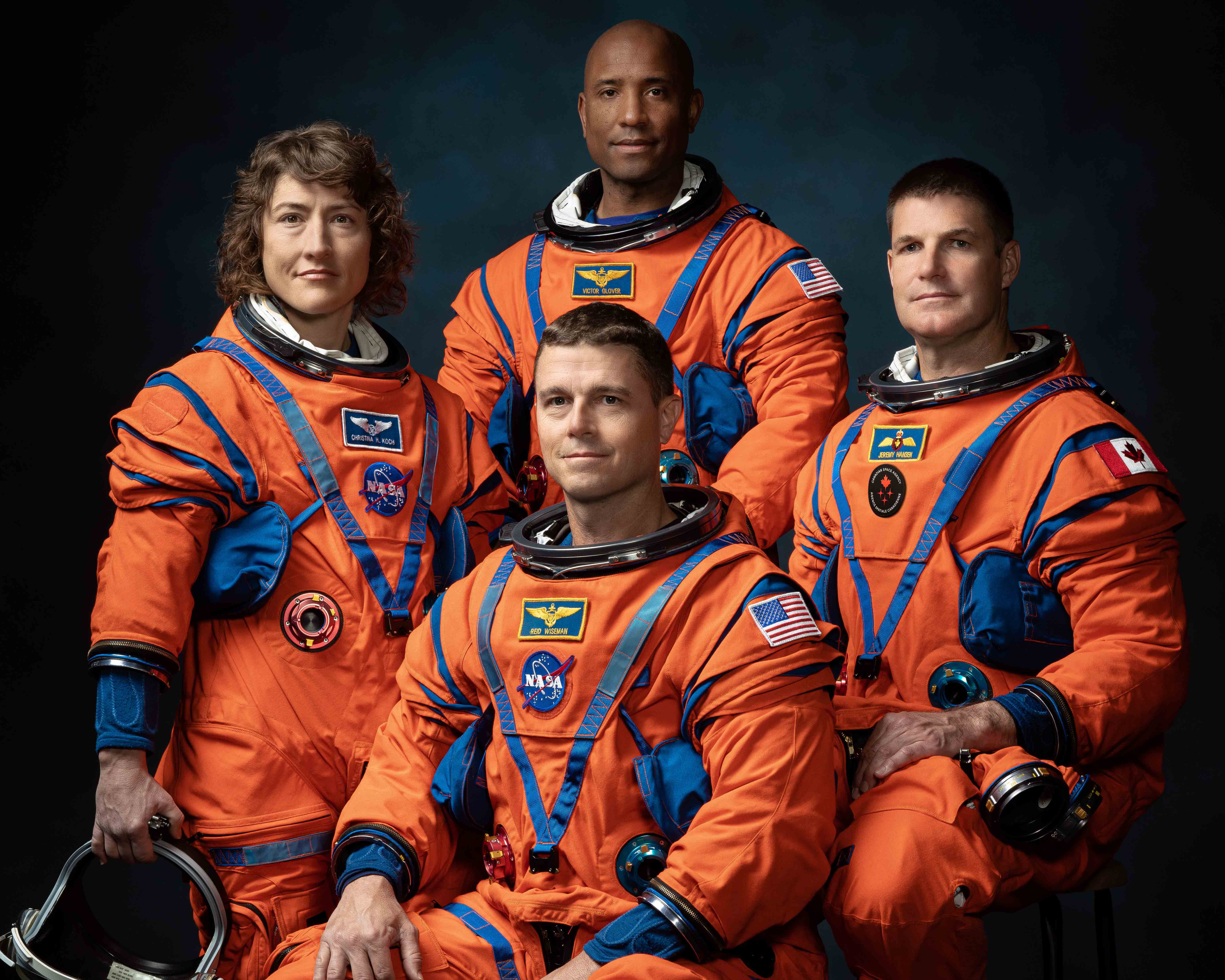 The four-member crew of NASA's Artemis II mission poses for a formal portrait in orange space suits.