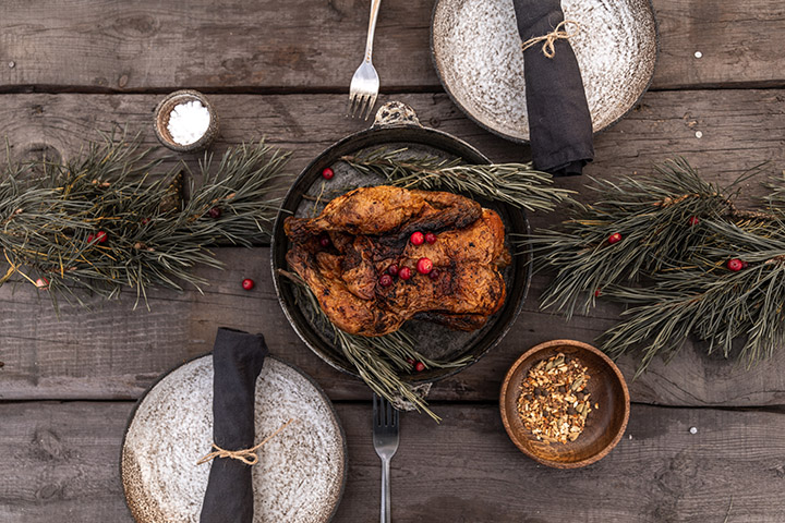A turkey, plates and decorations adorn a rustic table.