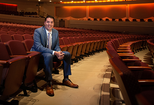 Ryan Gruss seated inside the Performing Arts Center