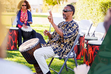 A participant and instructor during a drum circle held on Dexter Lawn during the Teach In, an annual event hosted by the College of Liberal Arts.