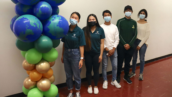 Students pictured with gold, green and balloon resembling globes at a past International Center event.