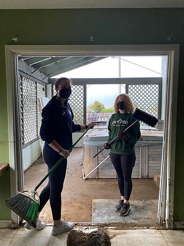 Madi Bennett-Wells, left, and Lily Fulton, right, clean up a home in Los Osos. 