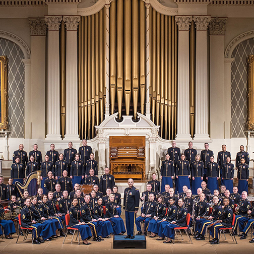 US Army Field Band sitting in a half circle with the commander in the middle 