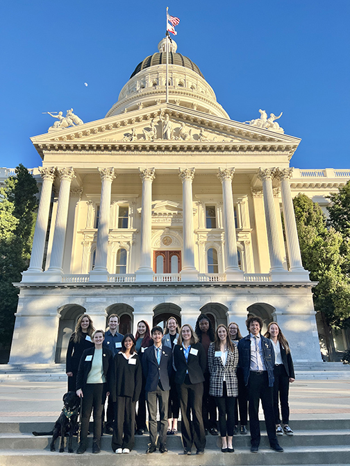 Nineteen Cal Poly students pose in front of the state Capitol building in Sacramento, Calif.