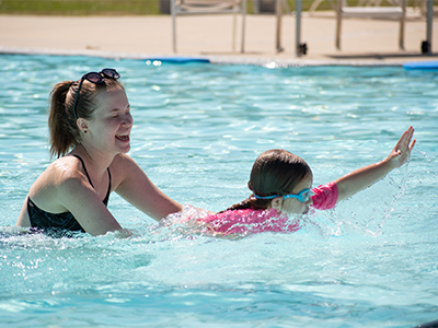 A child and instructor in the Cal Poly Recreation Center pool.