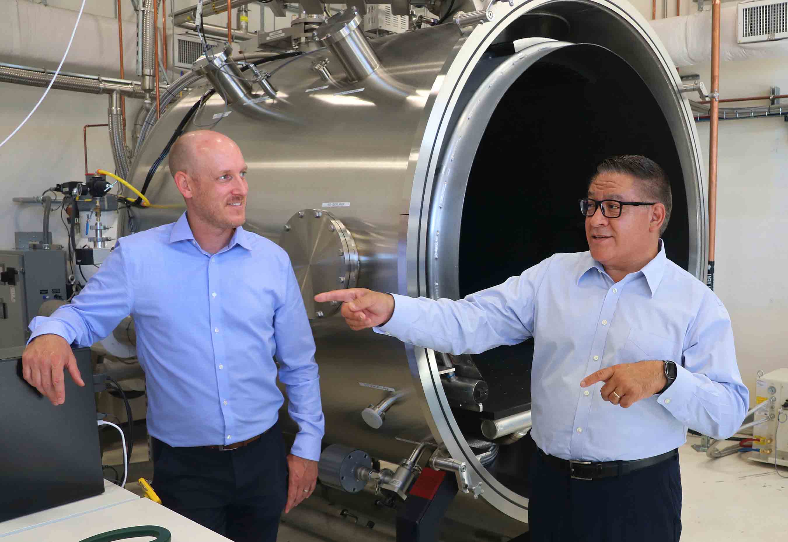 Aerospace engineering lecturer Cole Saucier, left, talks with U.S. Congressman Salud Carbajal at the dedication of the new Thermal Vacuum Chamber in the Advanced Technologies Lab.