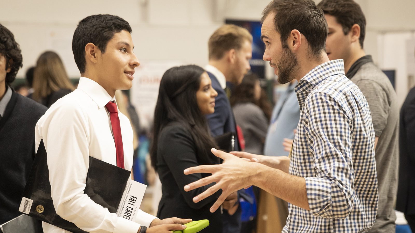 Student speaks with a recruiter at a career fair.
