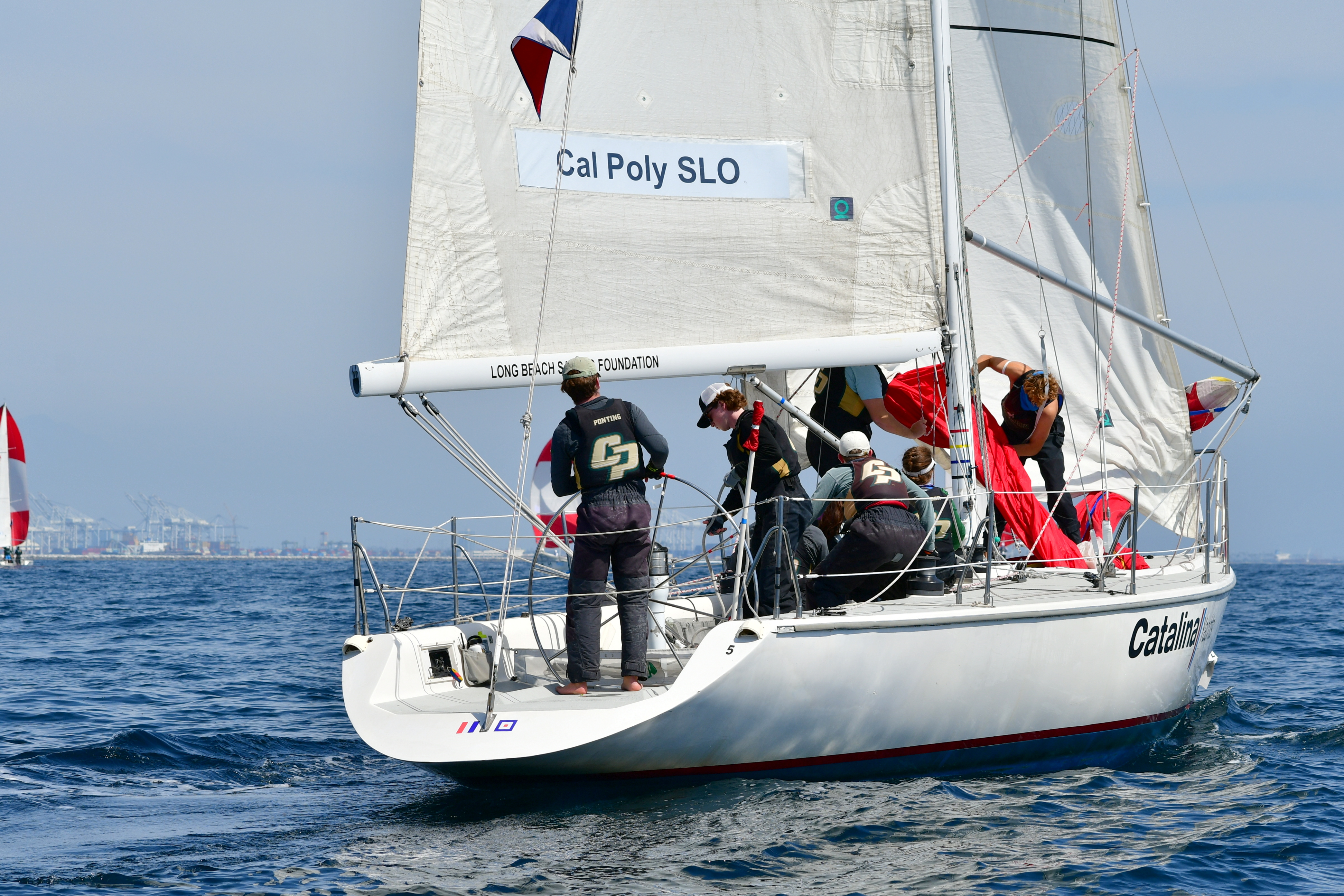 Cal Poly's sailing club works together on their boat during a race on the ocean in March.