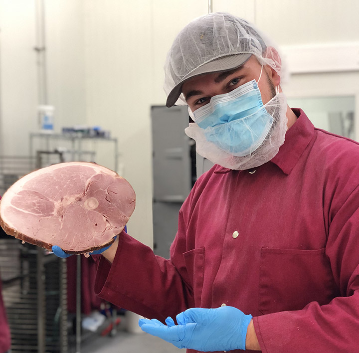 Avery De Mello, an animal science senior from Delhi, California, displays a Cal Poly ham.