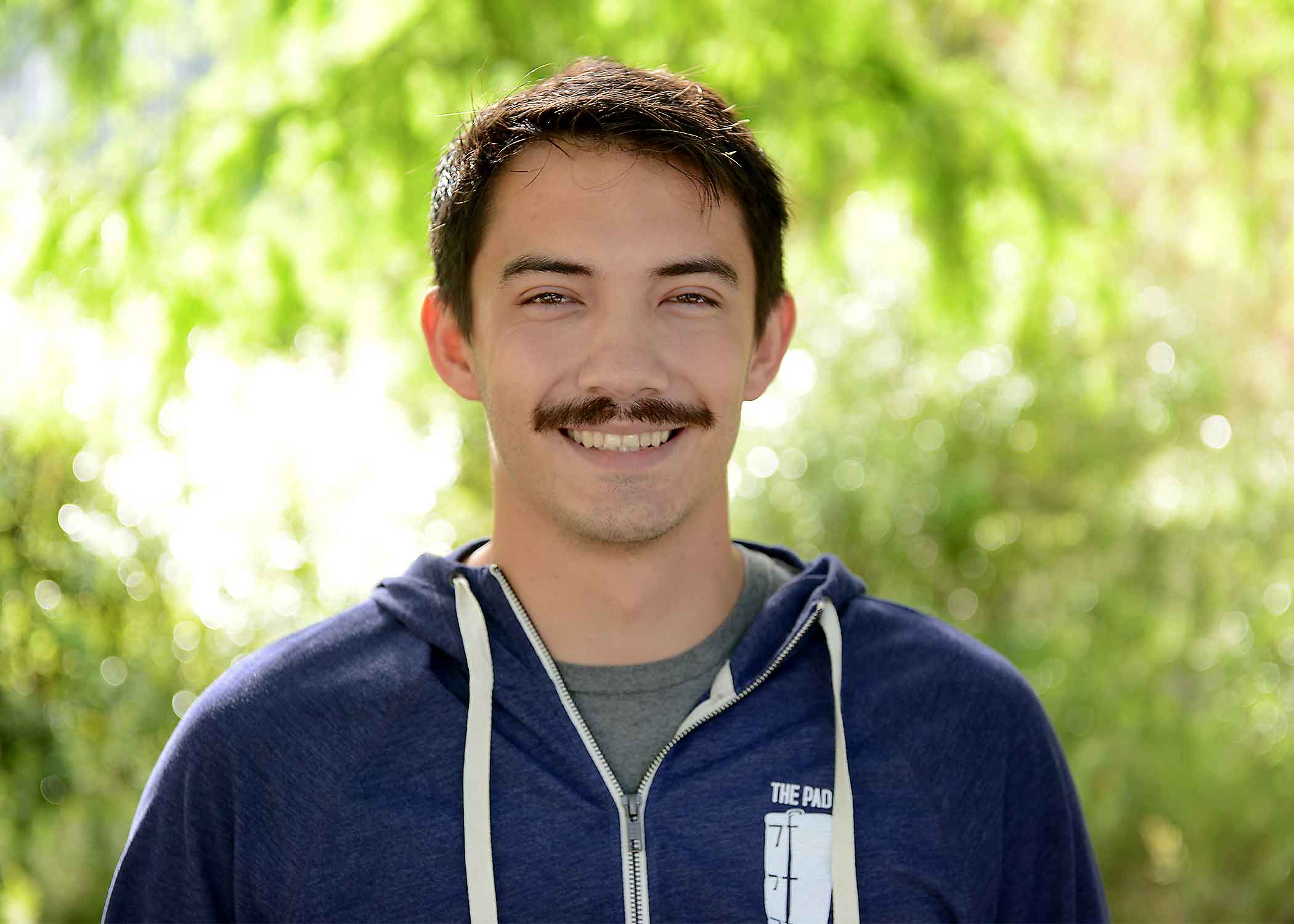 James Carlson, a 2019 Cal Poly graduate, smiles for a photo on campus.