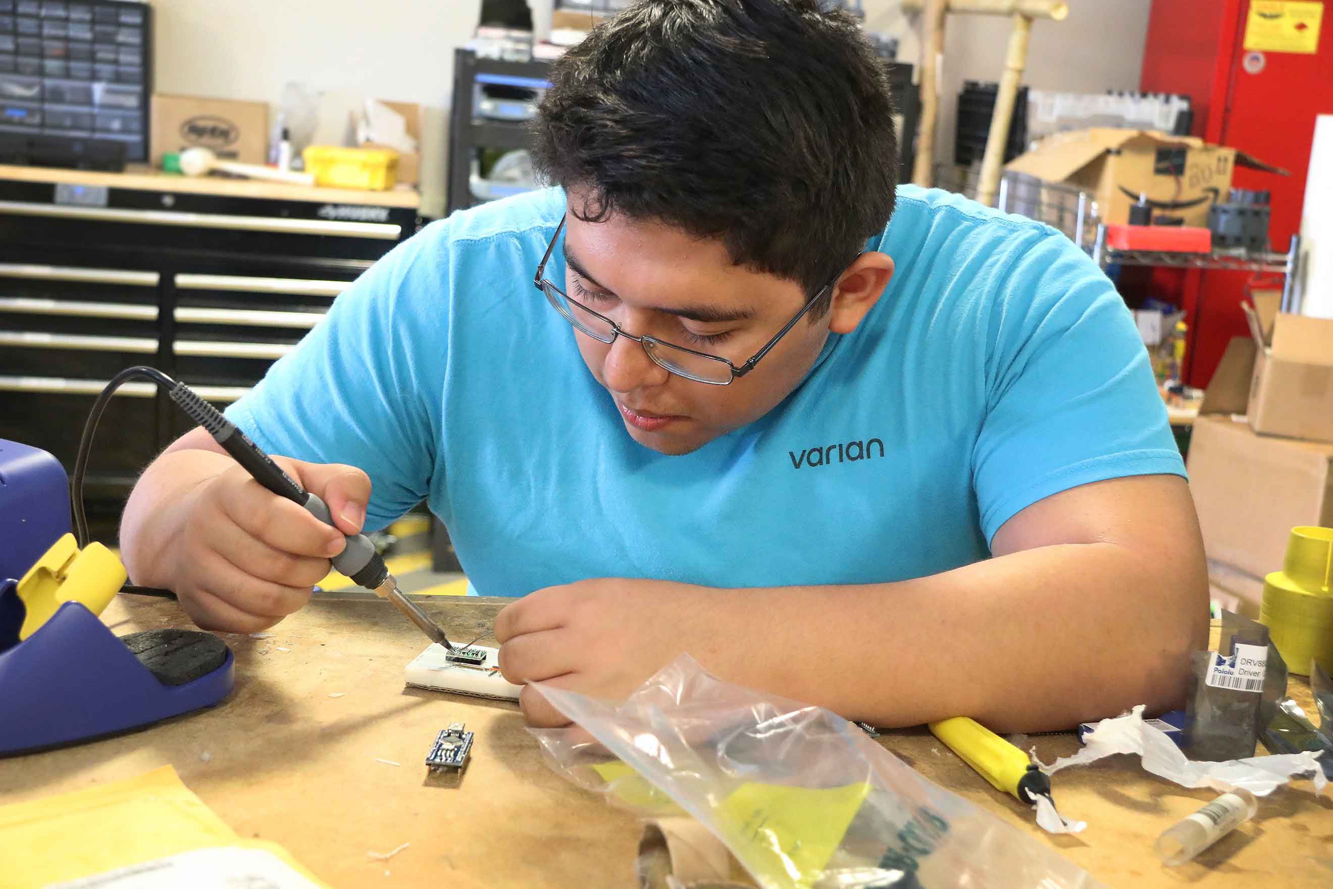 Student Christian Aguirre works with wiring that will be used on Julian's left hand