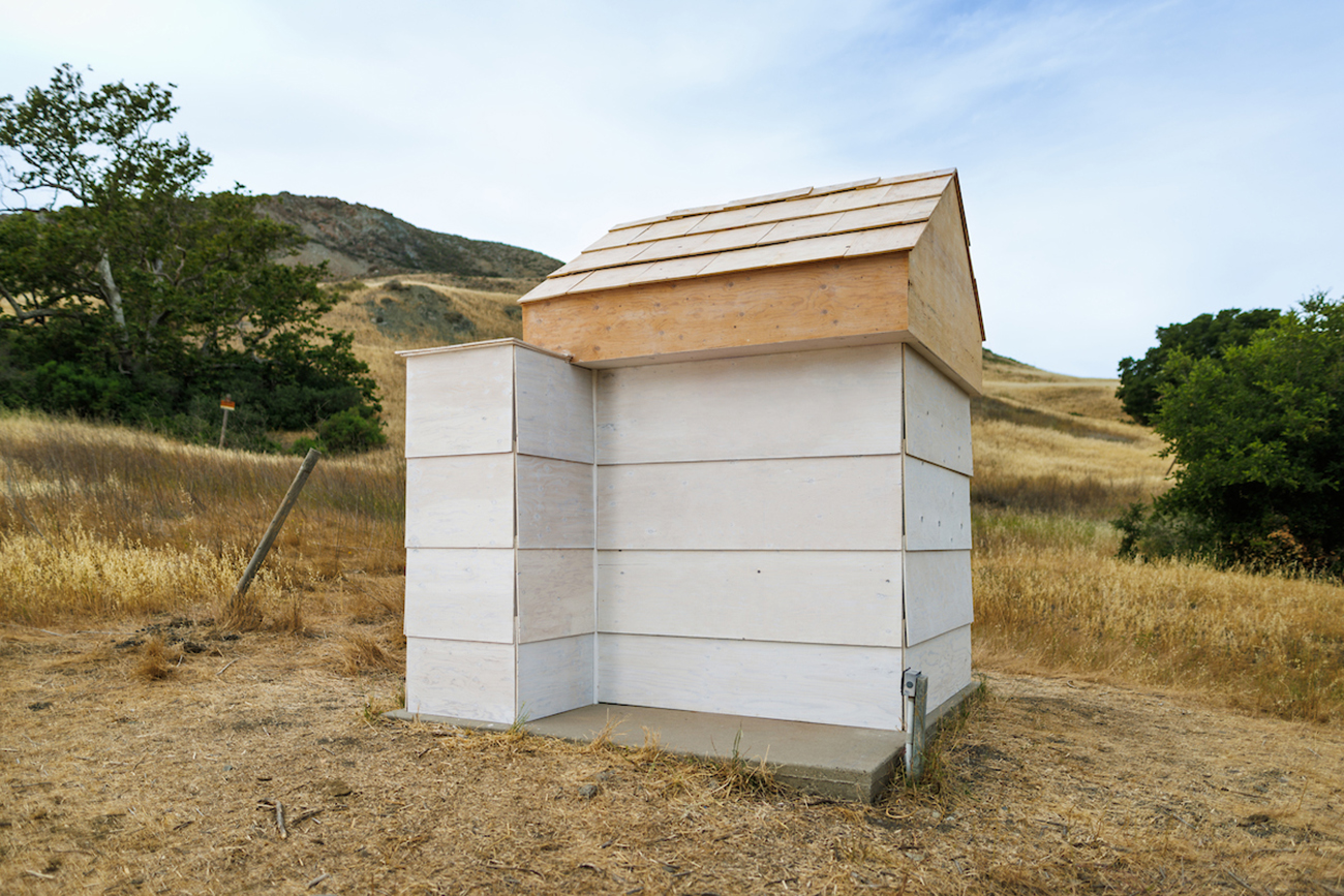 A view of a white shed-like structure built on a hillside in Poly Canyon