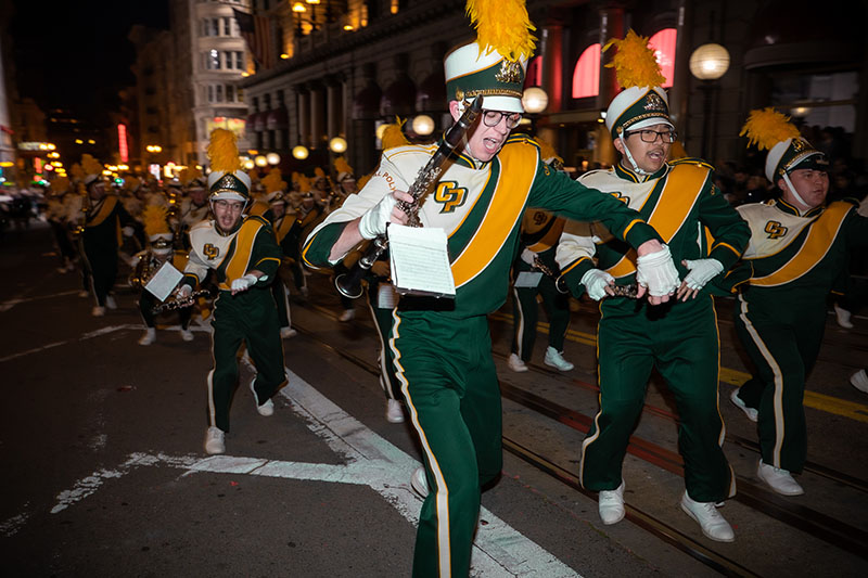 Mustang Band members dancing at night through the streets of downtown San Francisco