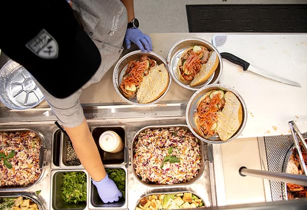 An aerial view of a staff member making sandwiches at a food counter