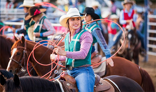 Photo of a female student in a past rodeo event along with other participants.