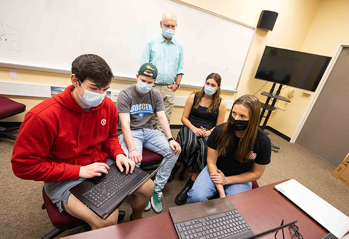 A team of Cal Poly students designed a mobile app for the World Bank to help improve school safety in developing countries, projecting to reduce cost and time by 50%. From left, Nicholas Hansen (Computer Science, 2022), Zachary Cipolla (Computer Science, 2022), Elisa Horta (Mechanical Engineering, 2023), Melissa Nardone (Computer Engineering, 2022) and Professor Franz Kurfess meet remotely with the World Bank's Global Program for Safer Schools team. Photo by Joe Johnson, Cal Poly