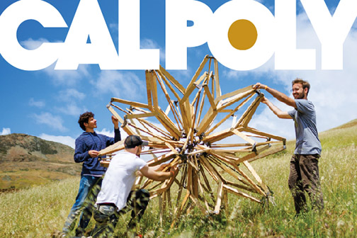 Three students install a large wooden Hoberman Sphere in Poly Canyon on a sunny day with the words ‘Cal Poly’