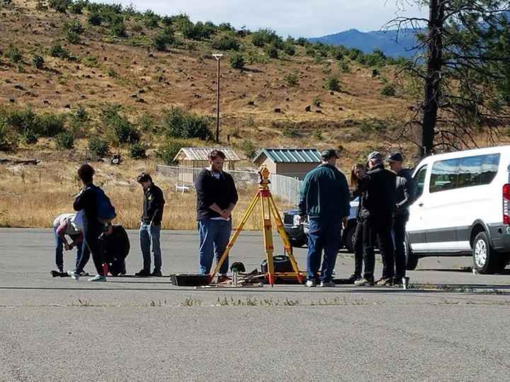 A group of architecture students work with survey equipment