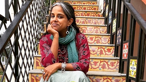 Portrait of Professor Anu Taranath on colorful steps