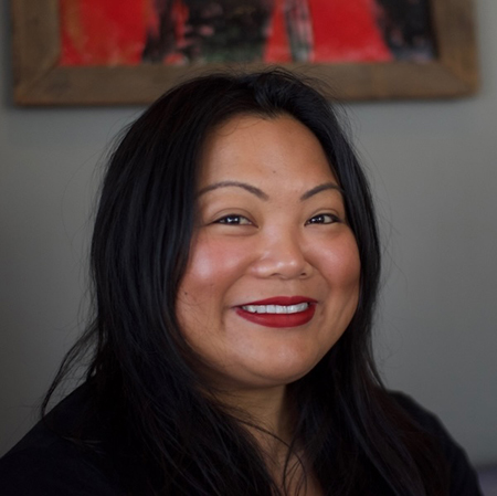 Portrait of San Jose State sociology Professor Joanne Rondilla smiling in a cafe interior. 