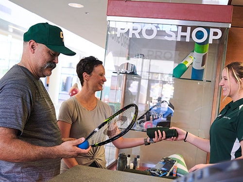 Staff members receive rackets at the Pro Shop