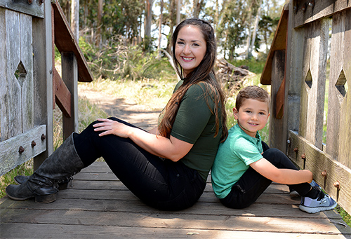 Aubree Charlesworth, a 2019 Cal Poly Graduate, poses sitting and back-to-back with her young son, Andrew. 