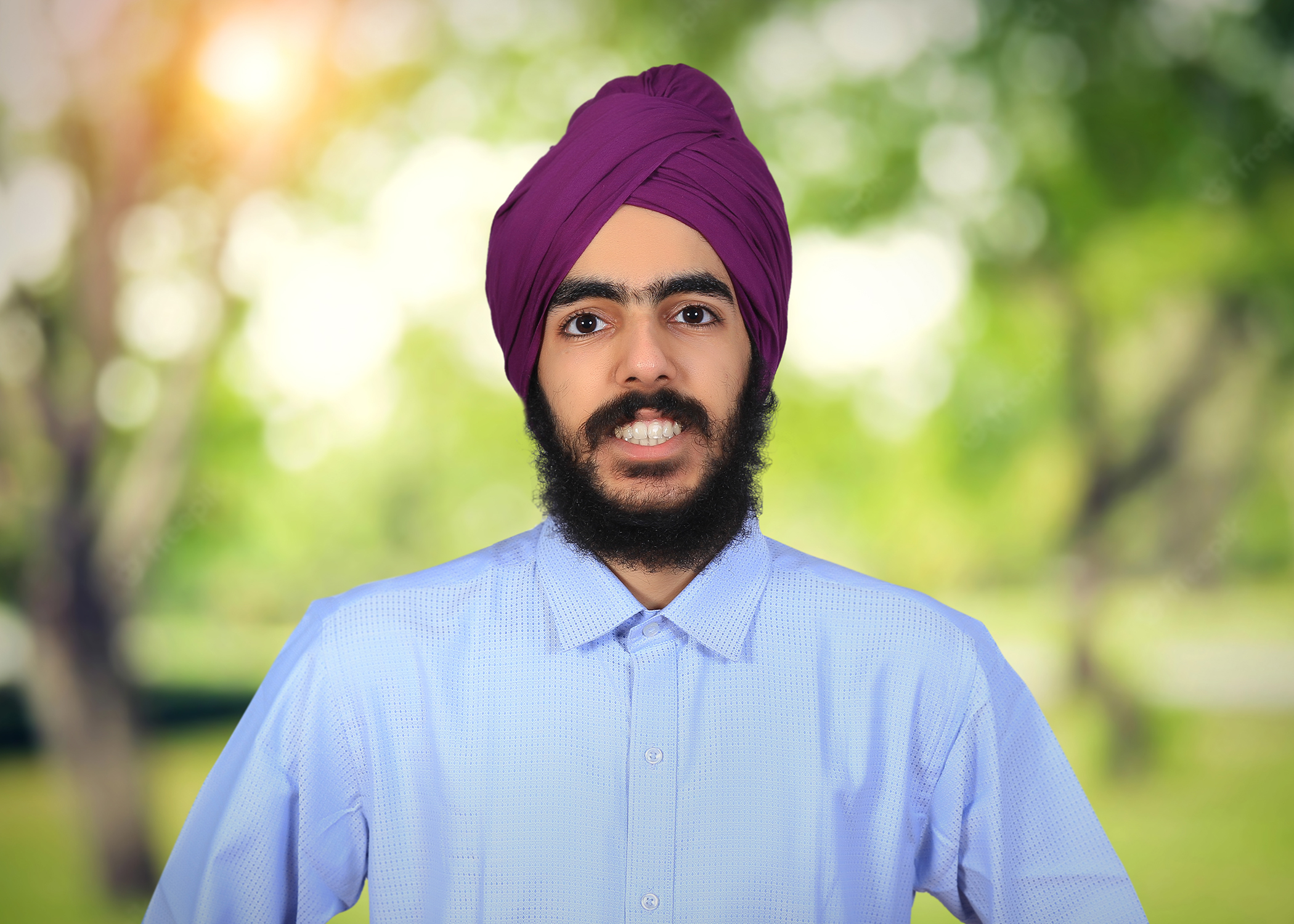 A portrait of a young man in a beard, turban and collared shirt