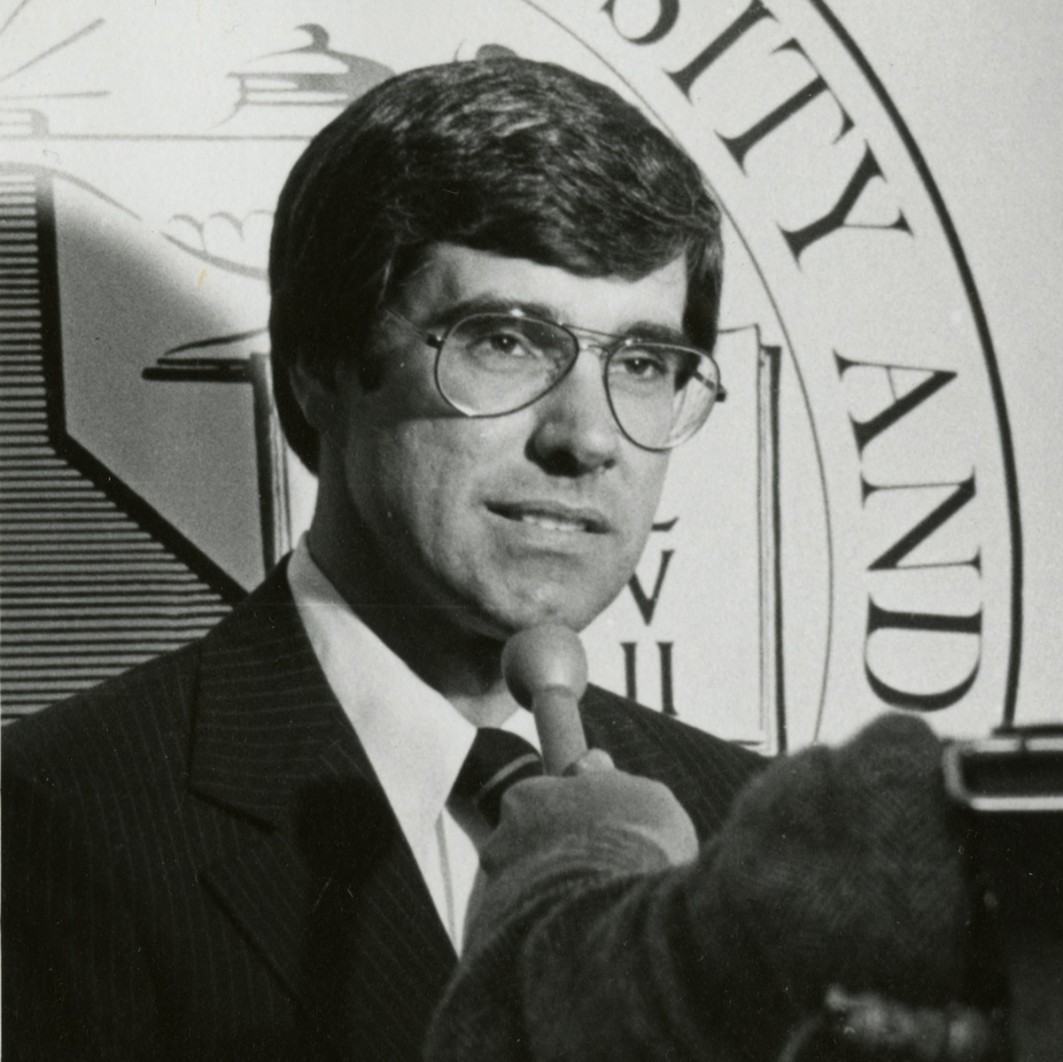 Warren Baker speaks into a microphone in 1979