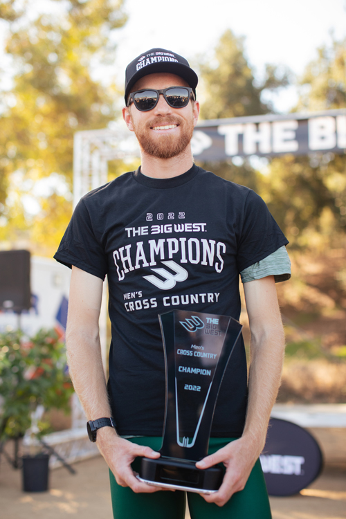 Jake Ritter wears a black shirt and holds a Big West championship trophy.
