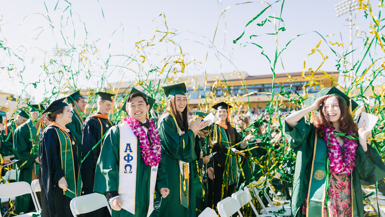 Streamers fly as graduates in cap and gown smile