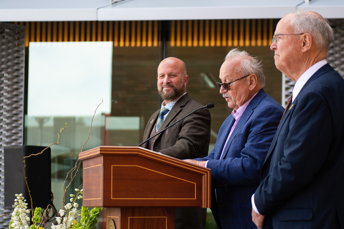 Dean Wendt (left), dean of the College of Science and Mathematics, William Frost (center) and Phil Bailey (right) speak at a podium.