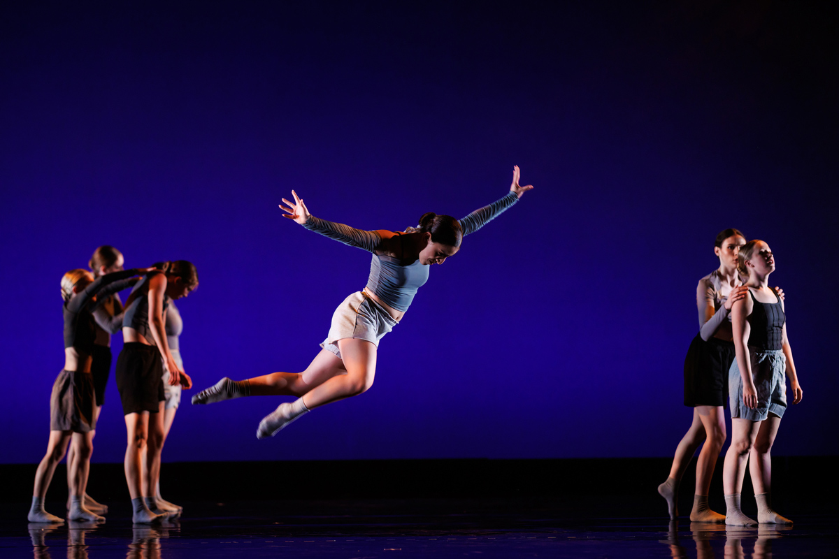 A performer jumps on stage during a dance concert